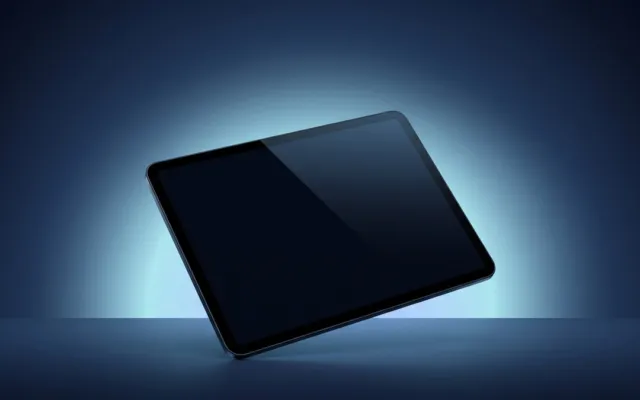 Tablet escuro inclinado diante de um fundo azul iluminado